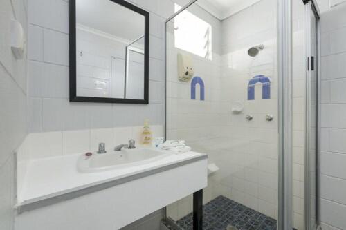 因尼斯费尔因尼斯费尔市汽车旅馆的白色的浴室设有水槽和淋浴。