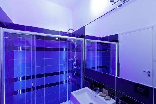 托雷拉皮罗Bed & Blues的蓝色瓷砖浴室设有水槽和镜子