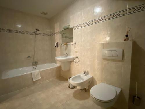 Tielt登霍克酒店的浴室配有卫生间、盥洗盆和浴缸。