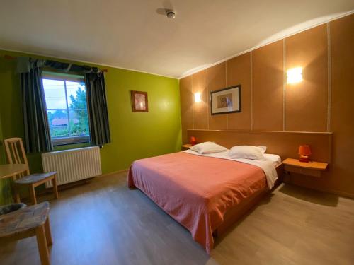 Tielt登霍克酒店的一间卧室设有一张带绿色墙壁和窗户的床。