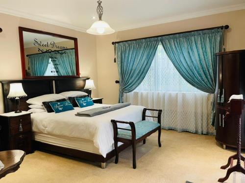绍斯布鲁姆Casa Alegre Guesthouse的一间卧室配有一张带蓝色窗帘的大床
