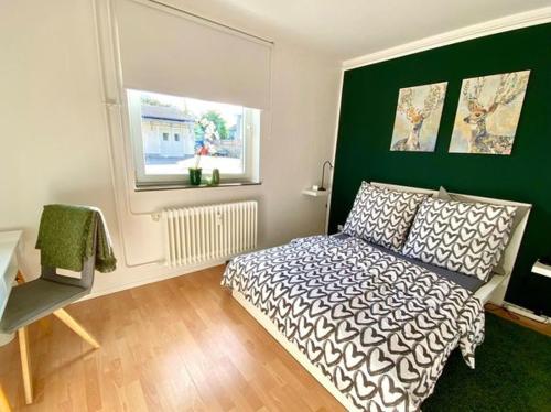 美因河畔霍海姆Die Zeitwohnung的一间卧室设有一张床和绿色的墙壁