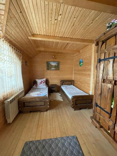 沃罗赫塔Вілла в Карпатах的小木屋内带两张床的房间