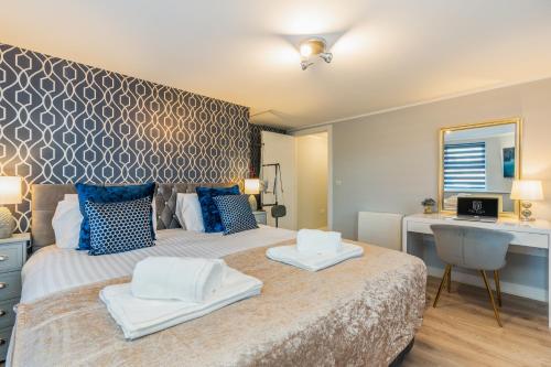 安德沃Charming Apartment In Andover Town Centre 55'' 4K Smart TV Netflix的一间卧室配有一张带蓝色和白色枕头的床