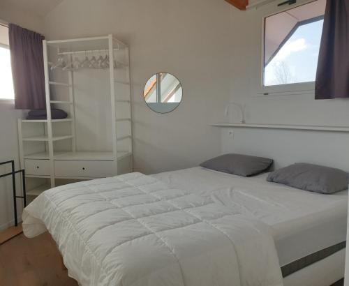 米德尔克尔克Duinengolf 5的卧室设有一张白色大床和一扇窗户。