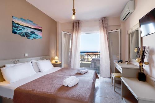 波利克罗诺Sueño beach hotel的酒店客房,配有带毛巾的床