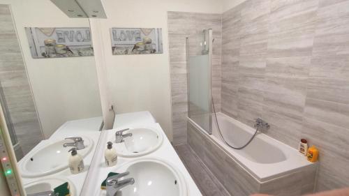 AlgrangeCocooning Logement entier [Parking Gratuit]的浴室配有两个盥洗盆和浴缸。