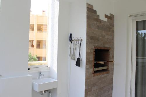 卡博皮诺BEACH FOREST PARADISE的一间带水槽和砖砌壁炉的浴室