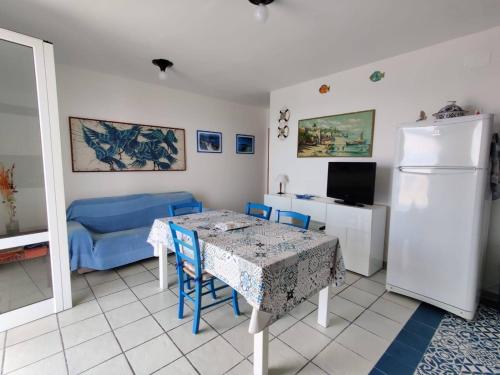 新福卡Villino sul mare的客厅配有桌子和蓝色沙发