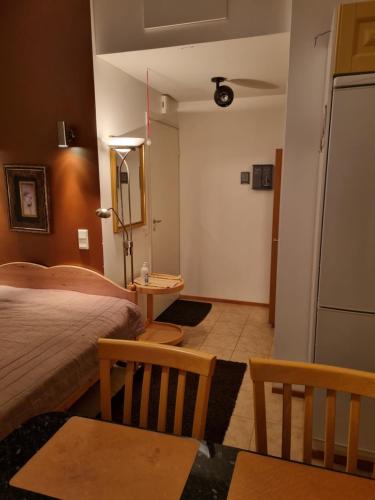 OulunsaloApartment Oulu Varjakka的一间卧室配有一张床铺、一张桌子和一台冰箱