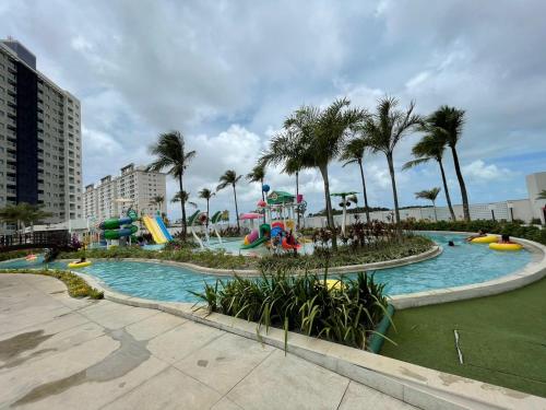 萨利诺波利斯Salinas Exclusive Resort的一个带滑梯和棕榈树的水上公园的游泳池