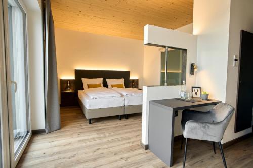 博登斯边的拉多夫采尔Hotel Kapelle的一间卧室配有一张床和一张桌子及椅子