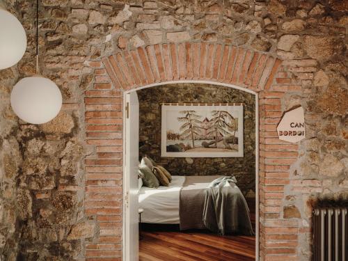 Llinars del VallèsParatgea的砖墙卧室,砖房里设有一张床