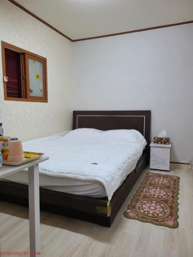 大邱Chenal Motel的一间卧室配有一张带桌子和地毯的床
