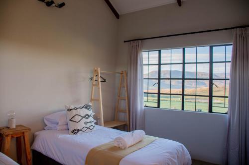 伯格维尔Kezlyn Farm Cottages的一间卧室设有两张床和大窗户