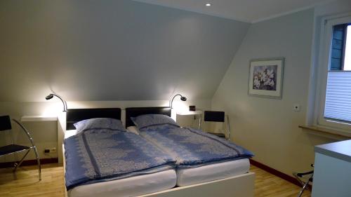 LipperreiheFerienwohnung Schuberski的一间卧室配有一张带两盏灯的床。
