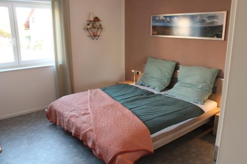 葡萄酒之路上的诺伊施塔特Ferienwohnung Andergasse的一间卧室配有一张带绿色枕头的床和一扇窗户