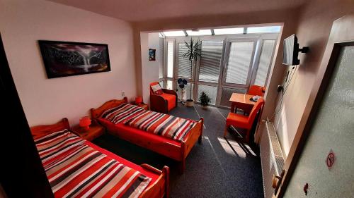 兹诺伊莫思蒂旅馆的客厅配有红色家具和窗户
