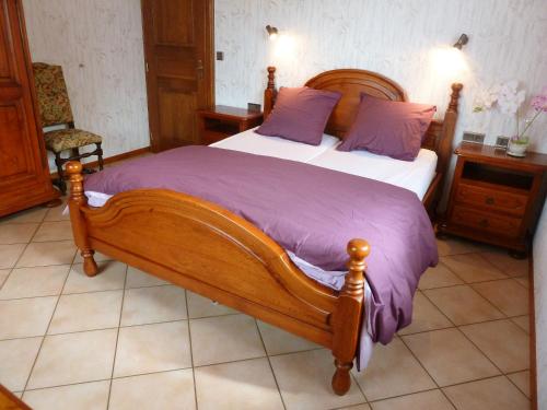 EpfigAppartement de 3 chambres avec wifi a Epfig的一间卧室配有一张带紫色枕头的大木床