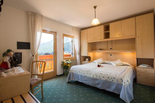 利维纳隆戈德尔科Hotel Garni Excelsior的一间卧室设有一张床和一个大窗户