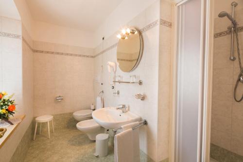 利维纳隆戈德尔科Hotel Garni Excelsior的一间带水槽、卫生间和镜子的浴室