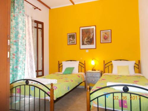 卡拉米锡Horizon Blue, Kalamitsi, Lefkas的黄色墙壁客房的两张床
