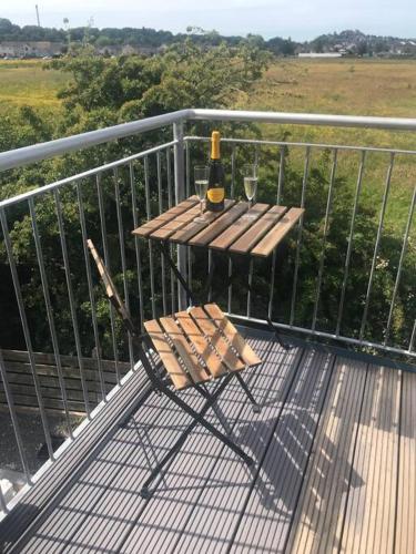 斯特灵Castle View - Home from Home的阳台上的桌子上摆放着一瓶葡萄酒