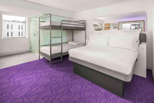 爱丁堡YOTEL Edinburgh的一间卧室配有一张双层床和紫色地毯