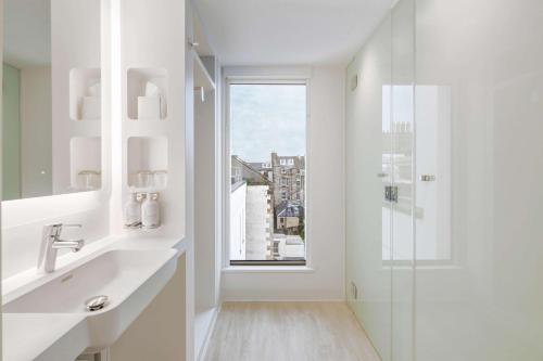 爱丁堡YOTEL Edinburgh的白色的浴室设有水槽和窗户。