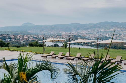 MuhariMantis Kivu Marina Bay Hotel的一个带躺椅和遮阳伞的游泳池