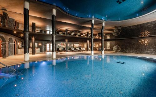 塞尔瓦迪加尔代纳山谷Hotel Portillo Dolomites 1966'的一座大型游泳池,位于一座带大型游泳池的建筑内