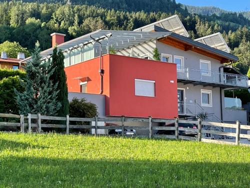 施瓦茨Apartments Evandi - Ferienwohnungen in ruhiger Lage的田野上带围栏的红色房子