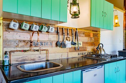 斯坦福AfriCamps at Stanford Hills的厨房配有绿色橱柜和水槽