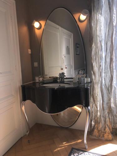 南特La Maison D'Hôtes Nantes Centre的浴室设有黑色水槽和镜子