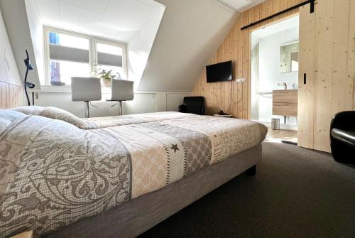 SpakenburgB&B Hartje Spakenburg的一间卧室设有一张大床和一个窗户。