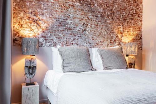 安特卫普BTFL Living Antwerp的卧室配有白色的床和砖墙