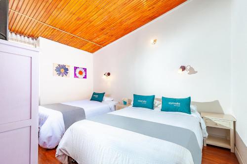 帕斯托Ayenda Casa La Castellana的卧室设有两张床铺和木制天花板