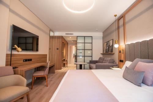 塞维利亚Hotel Giralda Center的配有一张床和一张书桌的酒店客房