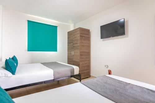 里奥阿查Hotel Casa Guajira Real的酒店客房设有两张床和一台平面电视。