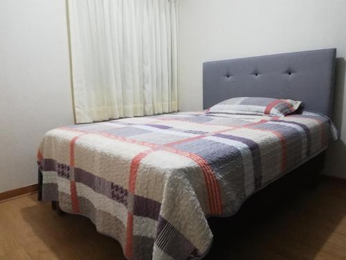 齐克拉约Colibrí的一间卧室配有一张床铺,床上有毯子