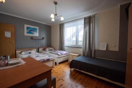 HuciskoSkalny Widok的酒店客房设有两张床和一张桌子。