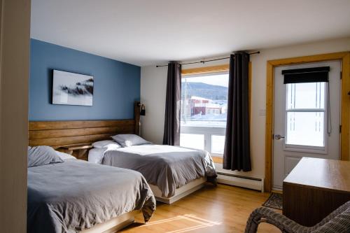 朗斯圣让Auberge de Jeunesse Le Camp De Base的一间卧室设有两张床和窗户。