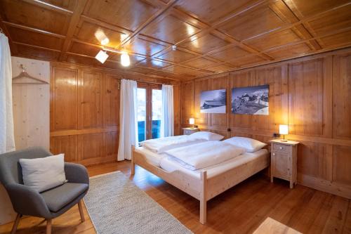 施伦斯Haus Buachwald的一间卧室配有一张大床和一把椅子