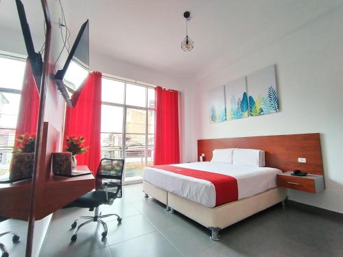 塔拉波托HOTEL SAN JUAN, Tarapoto的一间卧室配有一张带红色窗帘的床和一张书桌