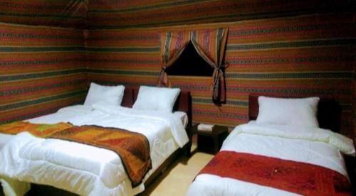 瓦迪拉姆Moon city camp的配有条纹墙壁的客房内的两张床