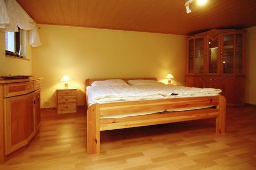 Klein SprenzCottage, Dolgen am See的一间卧室配有一张床、一个橱柜和两盏灯。