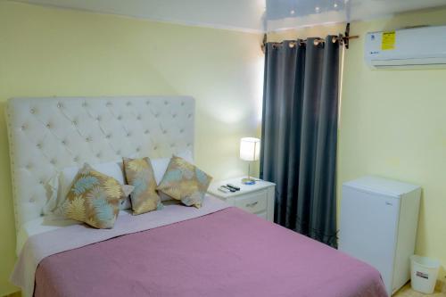 拉维加Hotel Anedi的一间卧室配有一张带紫色毯子和枕头的床。