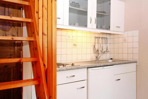 马克格拉芬海德Holiday home in Markgrafenheide with paid sauna的厨房配有白色橱柜和水槽