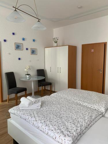 巴登-巴登纳塔利莱瑟民宿 的一间卧室配有一张床和一张桌子及椅子