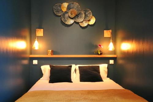 克拉马VILLA VOLTAIRE的卧室配有一张大床,墙上挂着灯